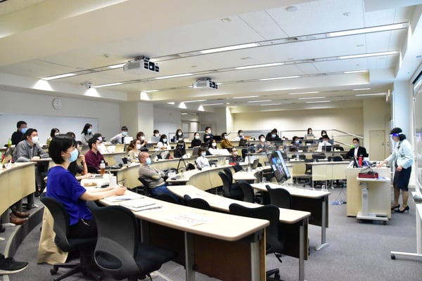 a full lecture classroom with people with masks